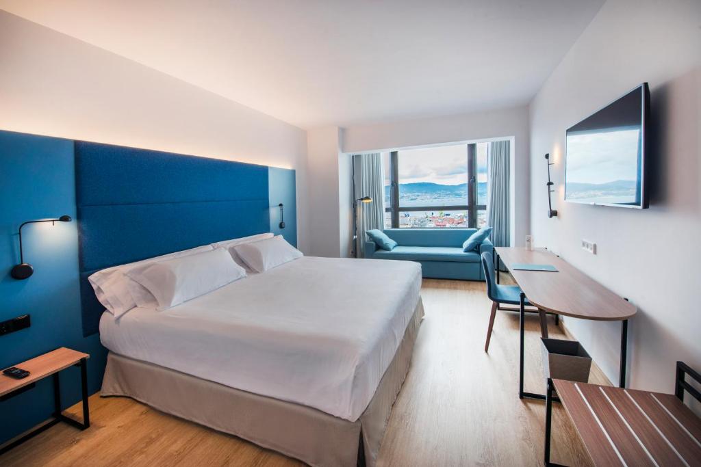 um quarto com uma cama, uma secretária e um sofá em Occidental Vigo em Vigo