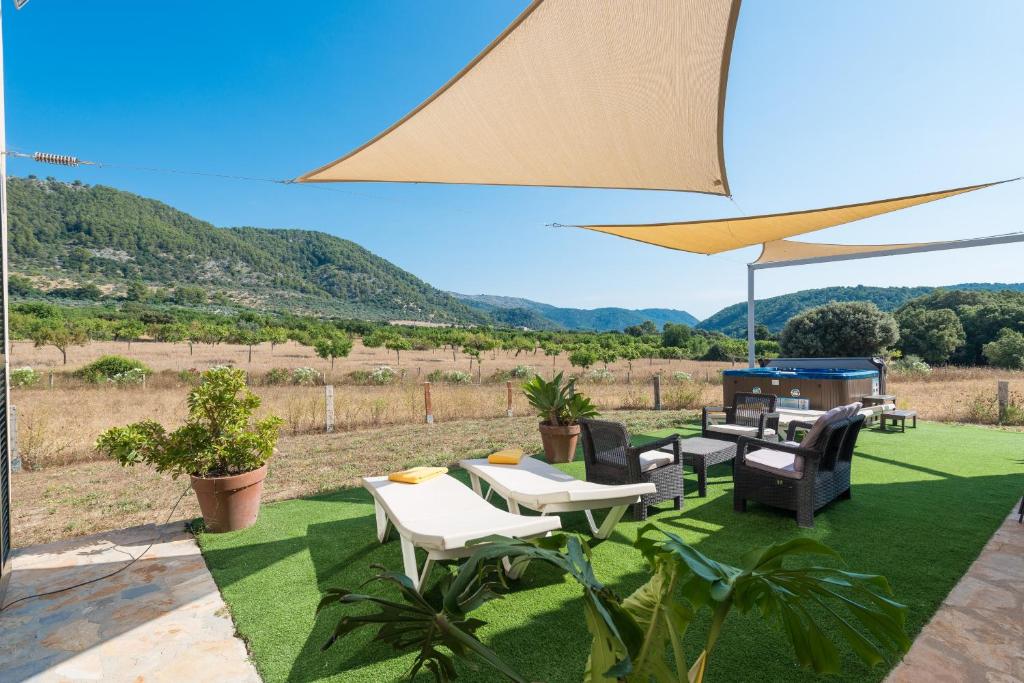 un patio avec des tables, des chaises et un grill dans l'établissement Villa S'Era, à Campanet