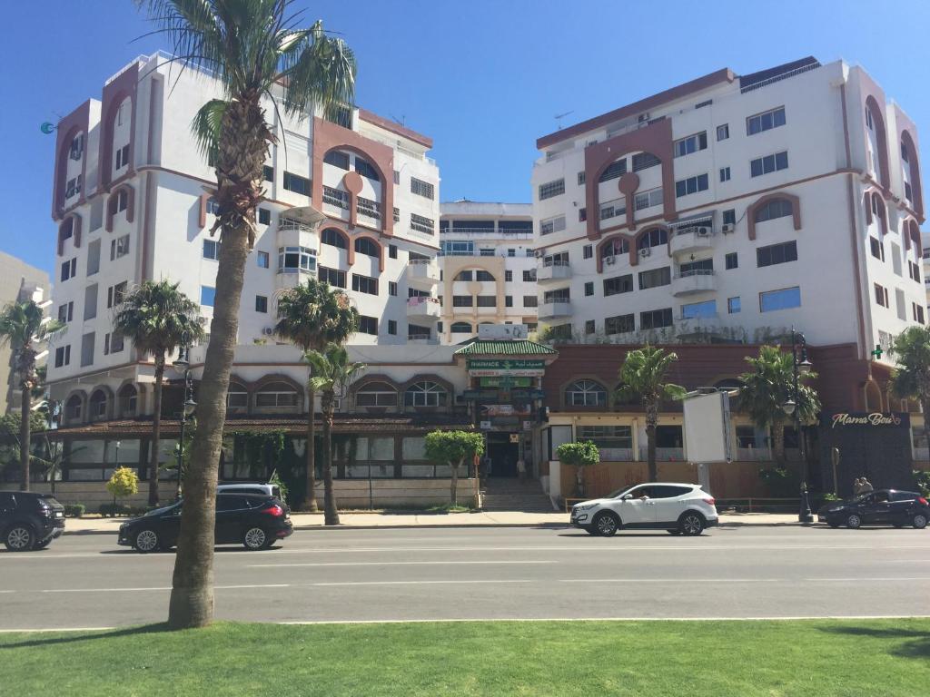 een parkeerplaats met auto's voor een gebouw bij Complexe Jardins andalouse in Tanger