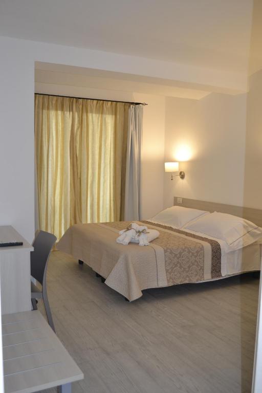 a hotel room with two beds and a window at Bentus B&B in Villasimius