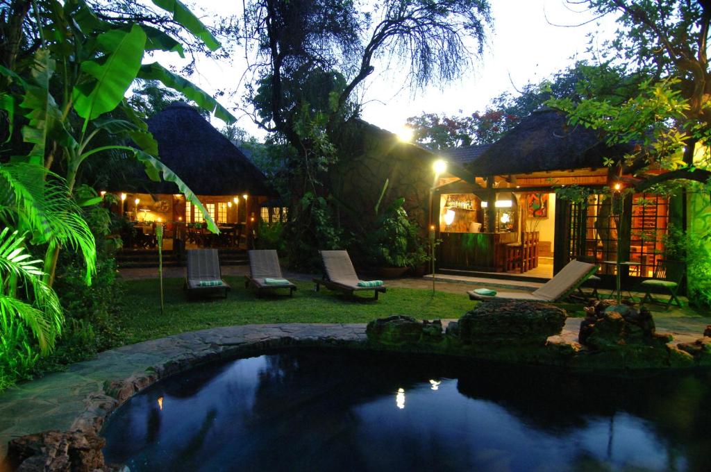 ein Pool im Garten eines Hauses nachts in der Unterkunft Kaia Tani Exclusive Guesthouse in Phalaborwa