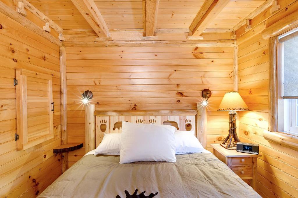 a bedroom with a bed in a log cabin at Cobble Mountain Lodge in Lake Placid