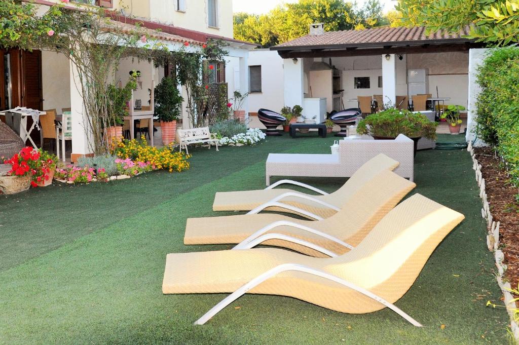 a row of benches sitting on a lawn at Villaiale in Sassari