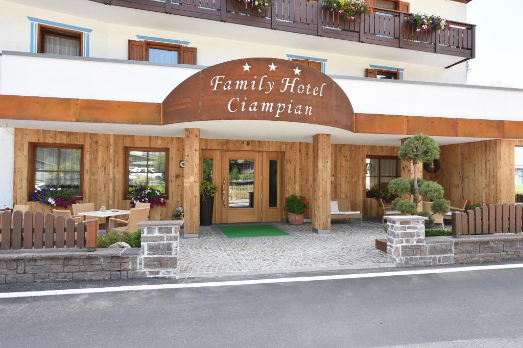 un bâtiment avec un panneau indiquant le champion de l'hôtel familial dans l'établissement Hotel Ciampian, à Moena
