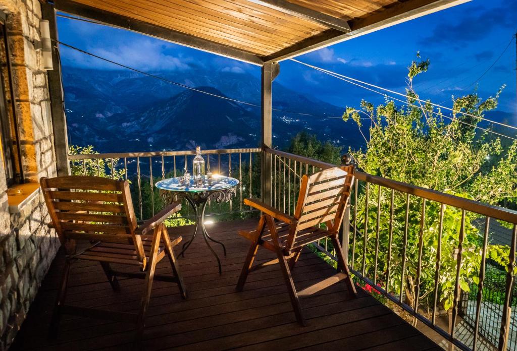 a patio with two chairs and a table on a balcony at Villa in the mountain in Ioannina