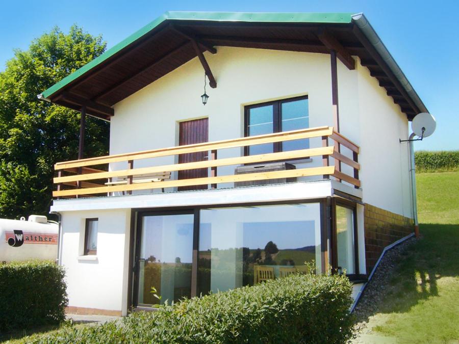 une maison blanche avec de grandes portes et fenêtres en verre dans l'établissement Haus Gieselsberg, mit Aussicht auf Schmalkalden, à Schmalkalden