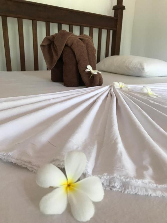 a stuffed elephant sitting on top of a bed with flowers at King's Elephant Cabanas & Restaurant in Tangalle