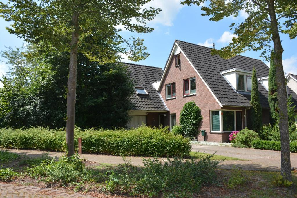 una casa con techo negro en Mango House Homestay, en Zuidwolde