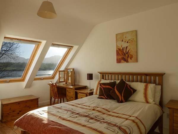 1 Schlafzimmer mit einem Bett, einem Schreibtisch und 2 Fenstern in der Unterkunft O'Connors Guesthouse in Faha
