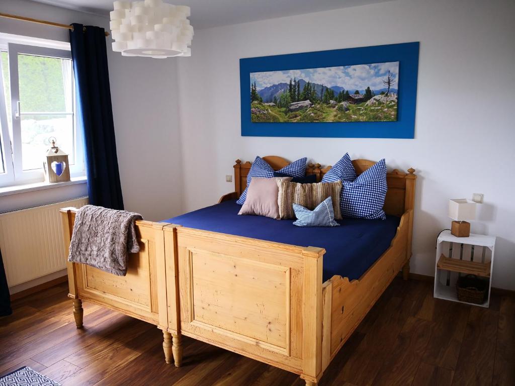 a bedroom with a wooden bed with blue sheets at Jägerstüble in Altusried
