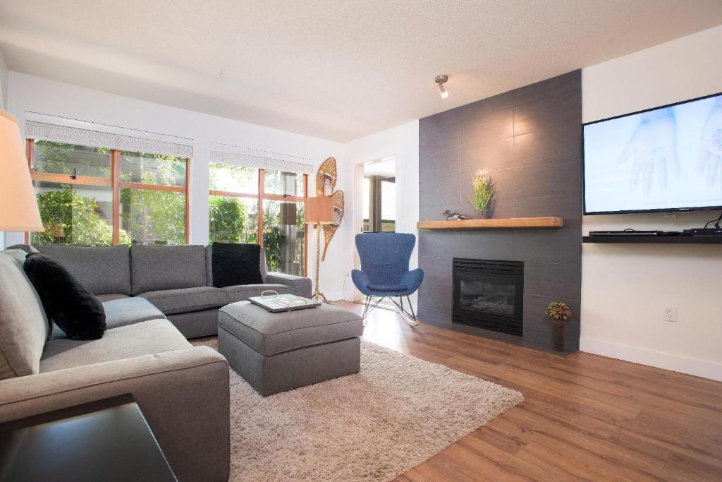 uma sala de estar com um sofá e uma televisão de ecrã plano em Northstar by Outpost Whistler em Whistler