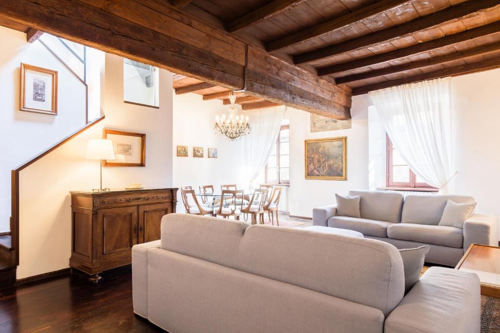 a living room with a couch and a table and chairs at Palazzo Del Pero Luxury Attic - byMyHomeinComo in Como