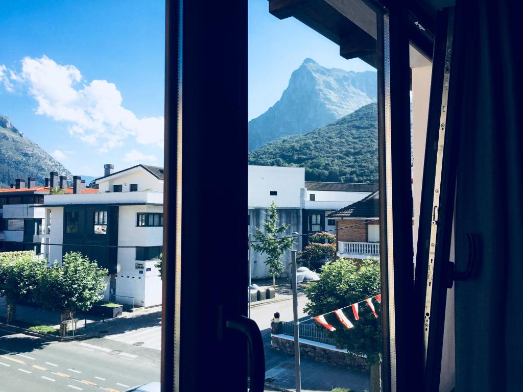 a view of a mountain from a window at Hotel Río Asón in Ramales de la Victoria