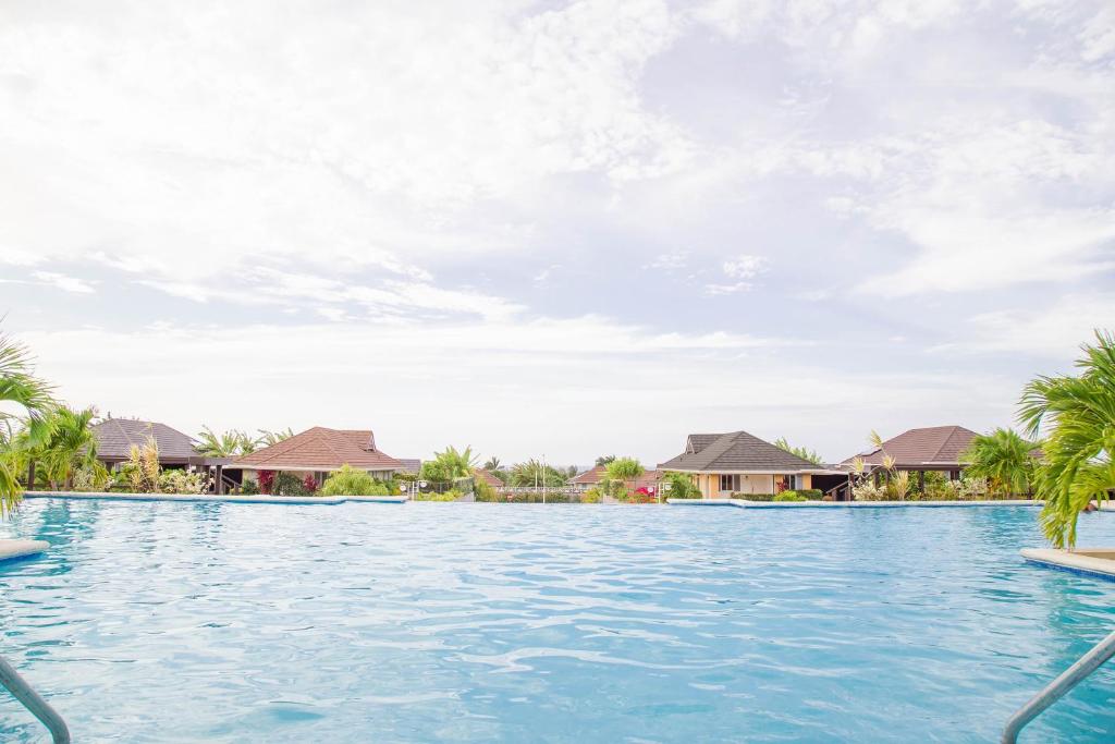a pool at a resort with palm trees and houses at Coolshade Villa Mahoe II Ocho Rios in Ocho Rios