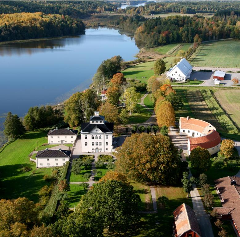 an aerial view of a house on a hill next to a lake at Öster Malma Hotel in Marieberg