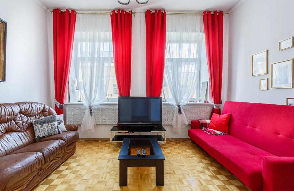 モスクワにあるApartment on Savvinskaya Naberezhnayaの赤い家具と赤いカーテンが備わるリビングルーム