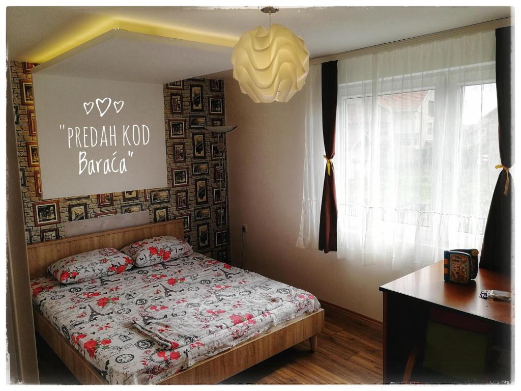 sypialnia z łóżkiem z napisem na ścianie w obiekcie Apartments "Predah kod Baraća" w Niszu