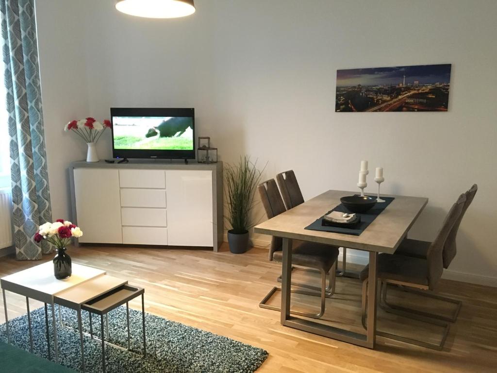 een woonkamer met een eettafel en een televisie bij Ferienwohnung Atze in Berlijn