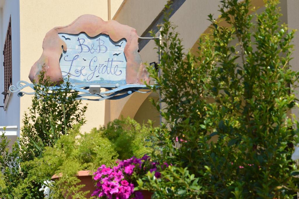 a sign on the side of a building with plants at Le Grotte in Castro di Lecce