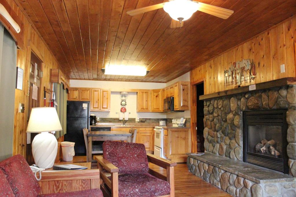 a living room with a stone fireplace in a house at Copper King Lodge in Red River