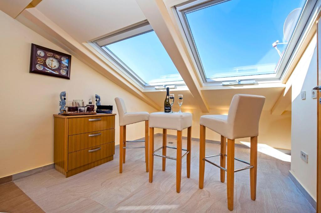 Habitación con mesa, sillas y ventana en Guest House Golden Goose en Rovinj