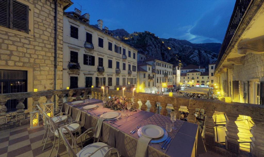 a table and chairs on a balcony of a building at Historic Boutique Hotel Cattaro in Kotor