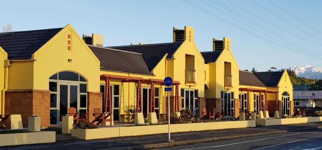 a row of yellow houses on a street at The Anchor Inn Beachfront Motel in Kaikoura