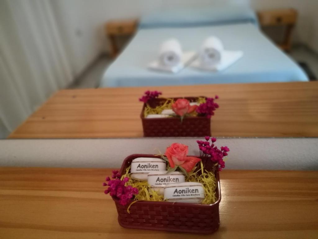 dos pequeñas cajas de jabón con flores en una cama en Aoniken Cabañas en Villa Cura Brochero