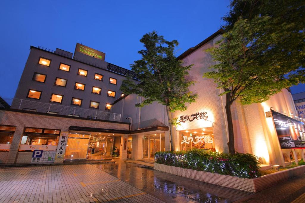 un edificio en una calle con un árbol delante en Green Hotel Yes Ohmi-hachiman, en Omihachiman