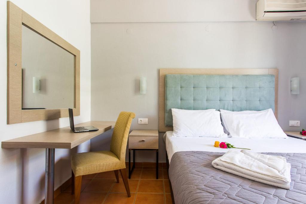 A bed or beds in a room at Coral Blue Beach Hotel Gerakini