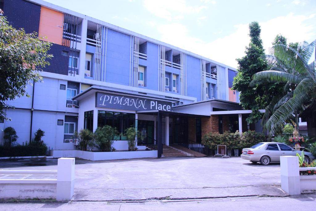 清萊的住宿－Pimann Place Hotel，前面有停车位的建筑