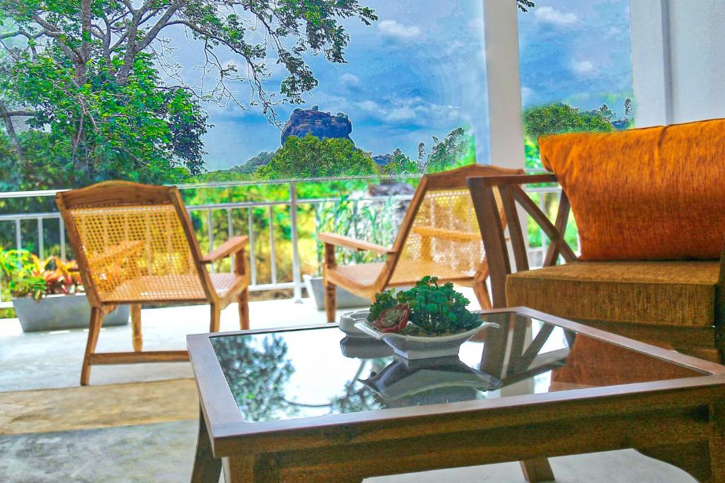 uma sala de estar com duas cadeiras e uma mesa de centro em Sigiriya Rock Hide em Sigiriya