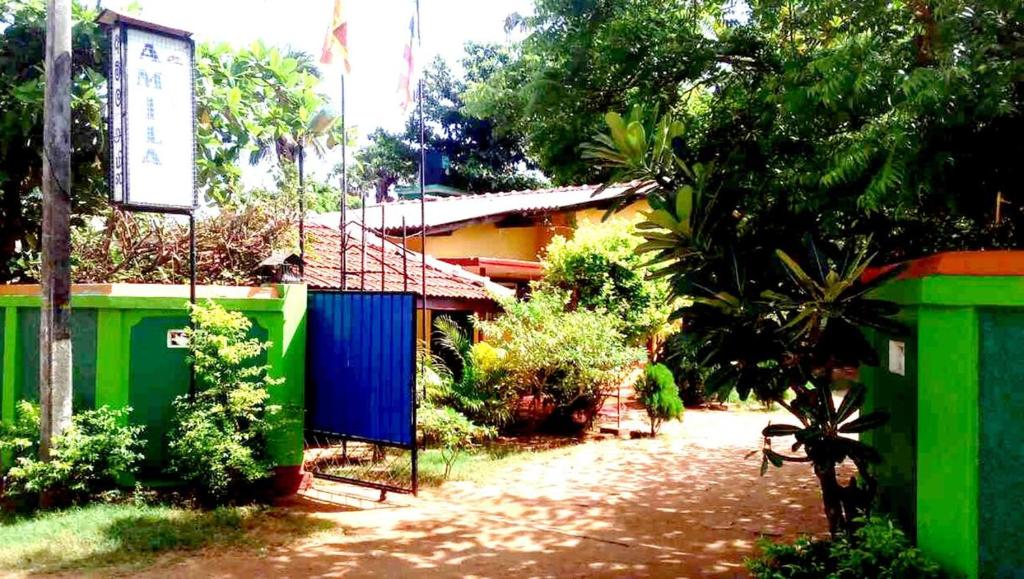 una casa con paredes coloridas y un camino de tierra en Amila Guest, en Trincomalee