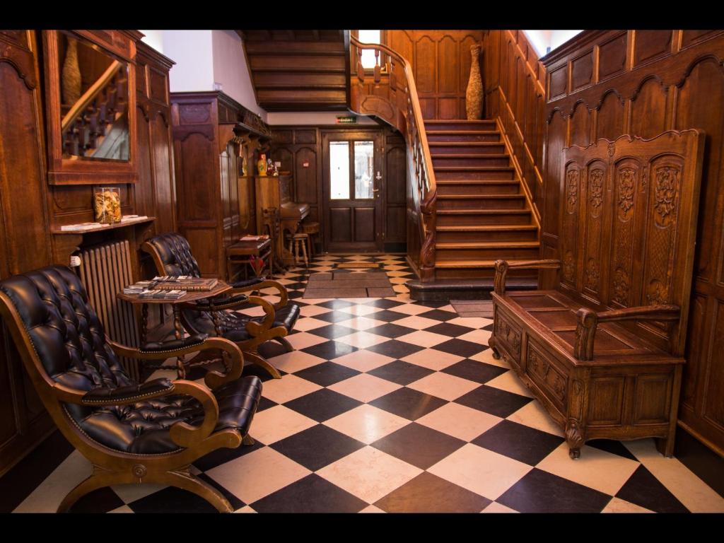 uma sala de estar com piso em xadrez e escadas em Au Manoir Des Vallees em Maffe