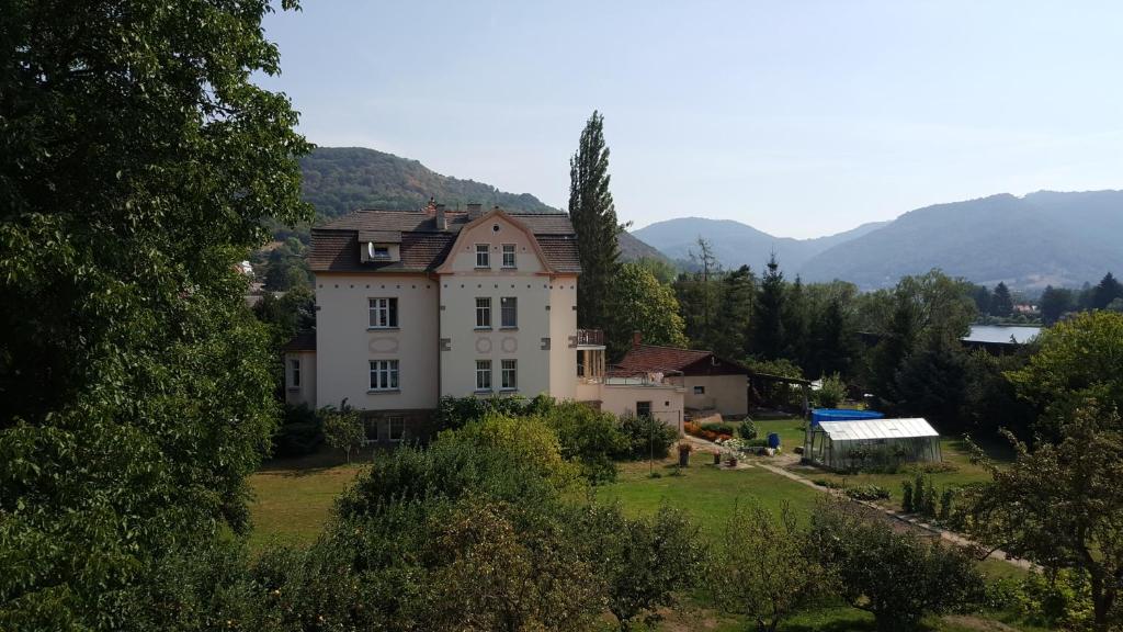 a house on a hill with mountains in the background at Villa Federer in Dolní Zálezly