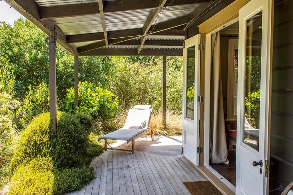 a porch with a bench on a house at Secluded Haven Near Bush, Beach & Havelock North in Havelock North