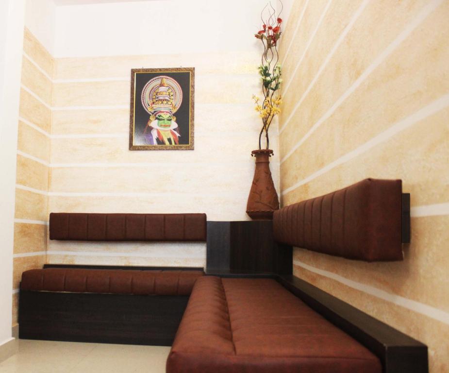 a room with a couch and a picture on the wall at Landy Queen in Munnar