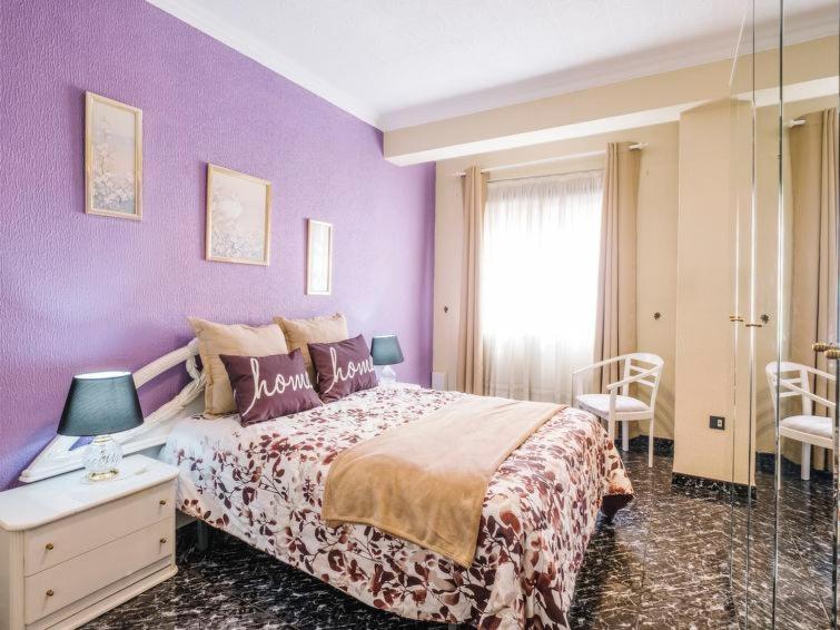 サンタクルス・デ・テネリフェにあるApartamento Centricoの紫色のベッドルーム(ベッド1台、窓付)