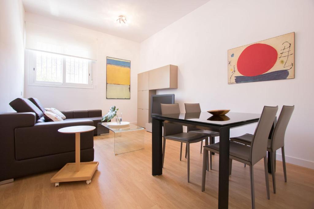 sala de estar con mesa negra y sillas en Murallas de Sevilla Apartamento con garaje 4 pax, en Sevilla