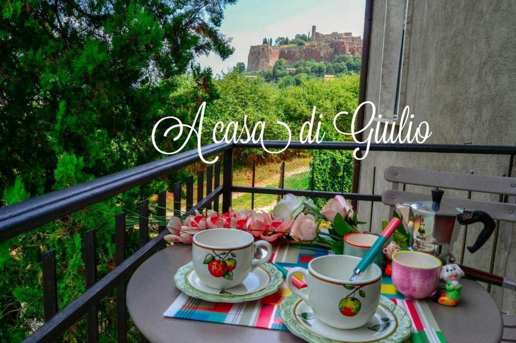 - une table avec des tasses de thé sur le balcon avec vue dans l'établissement Appartamento Orvieto A casa di Giulio, à Orvieto