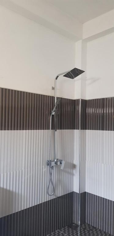 a shower in a bathroom with black and white stripes at Adhi's Place Ella in Ella