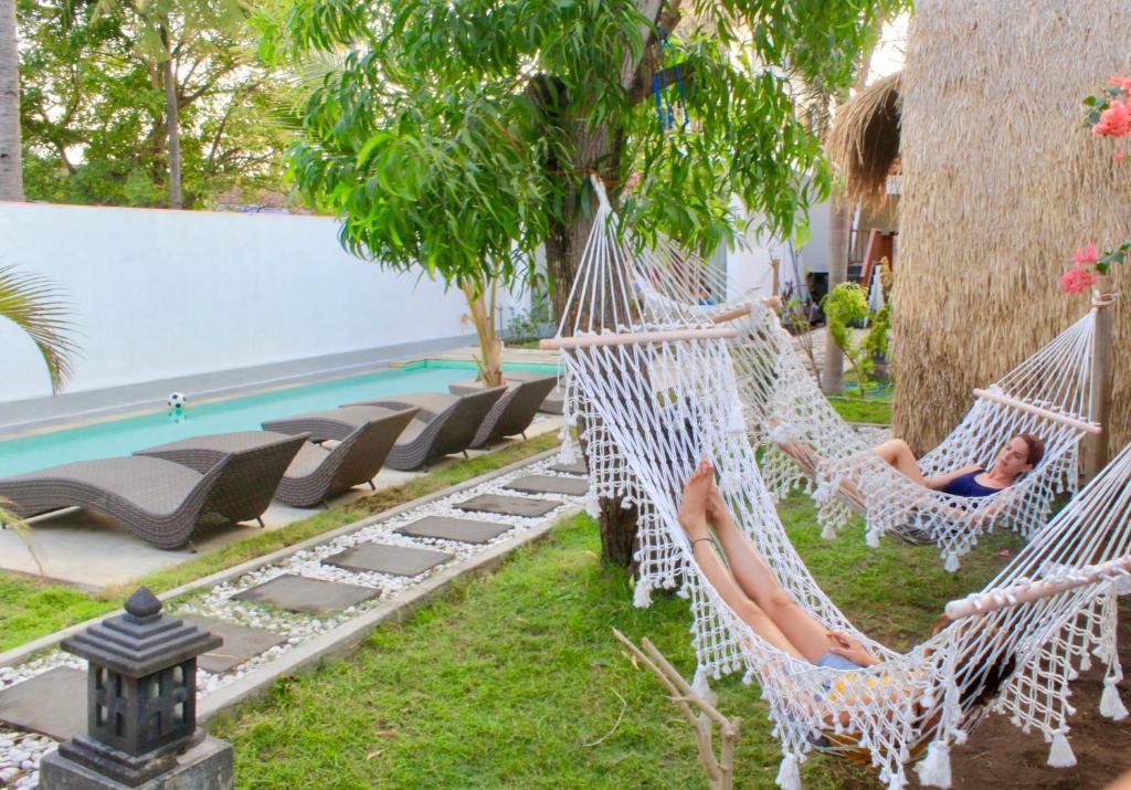 two people laying in hammocks by a pool at Gili Inlander in Gili Trawangan
