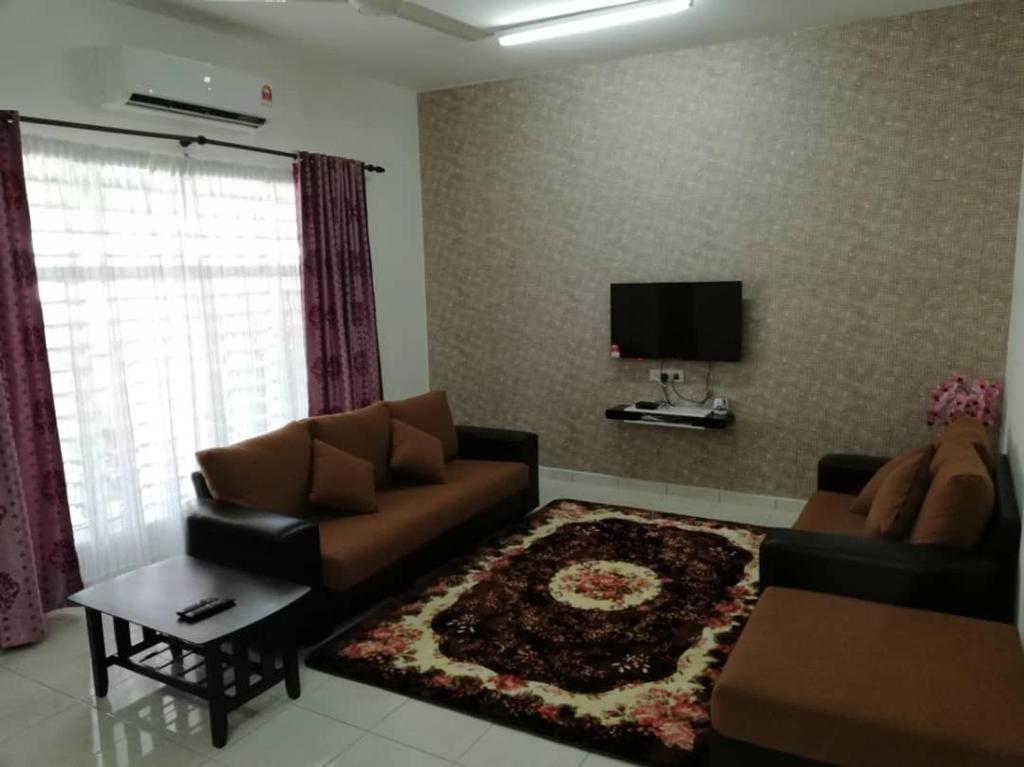 a living room with a couch and a tv at Faeyz Homestay Melaka in Melaka