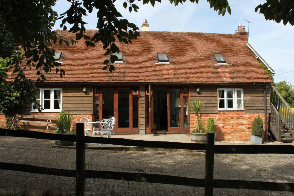 a house with a fence in front of it at High Street Farm Barn in Newbury