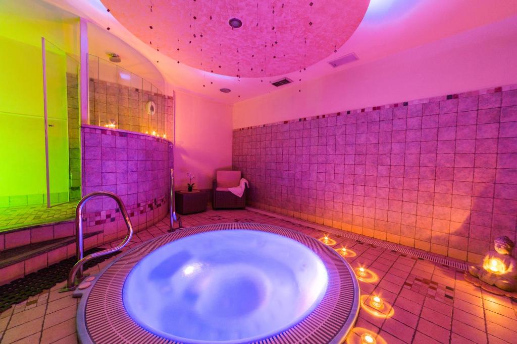 a large bathroom with a tub with lights in it at Hotel Palma Benessere in Rimini