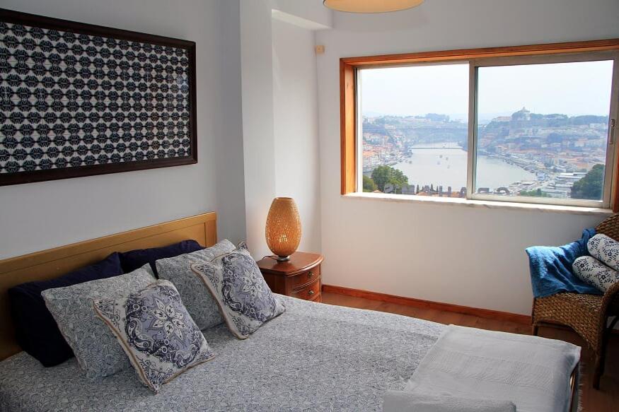 a bedroom with a bed and a large window at Historical Porto/Gaia Apartment in Porto