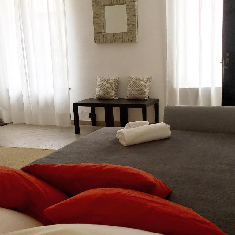 salon z kanapą i stołem z poduszkami w obiekcie Posidonia casa al Mare in Città w Genui