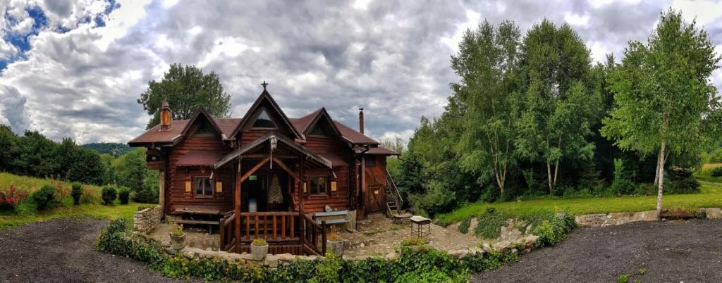 una grande casa in legno in mezzo a un campo di Cabana vânătorului a Rîşnov