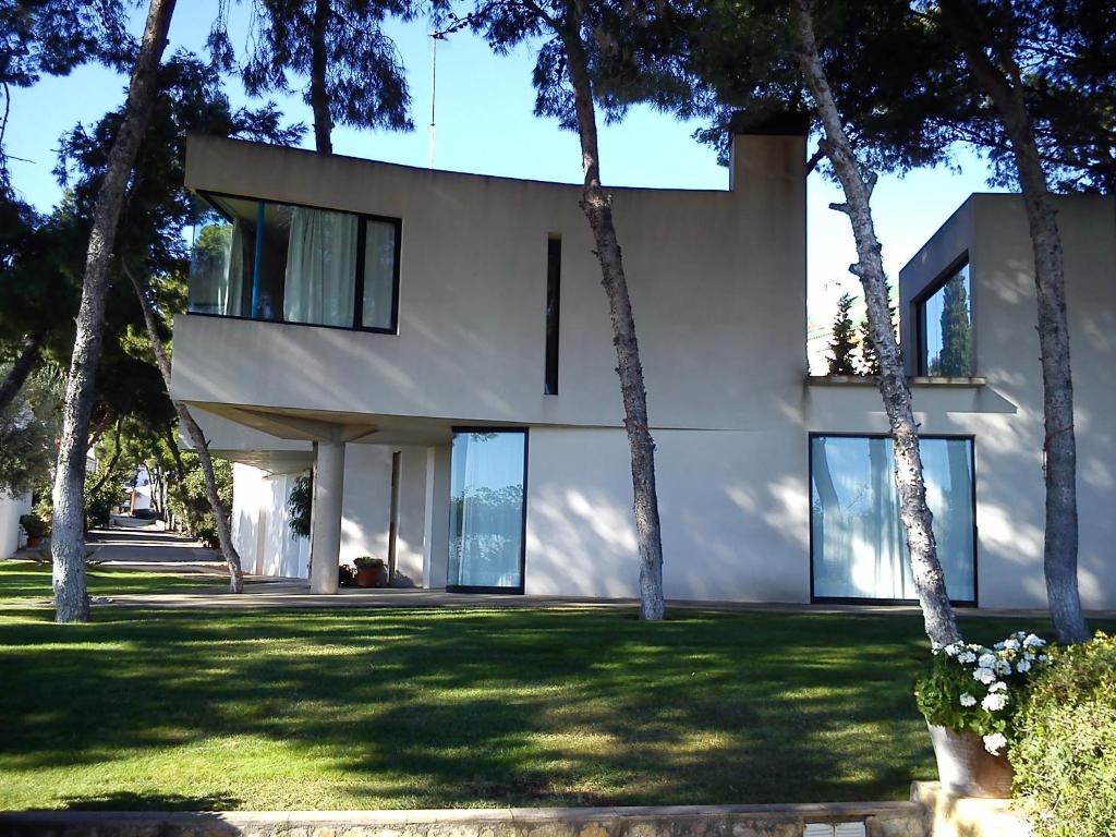 una casa blanca con árboles delante de ella en Villa Playa Delta del Ebro, en Sant Carles de la Ràpita