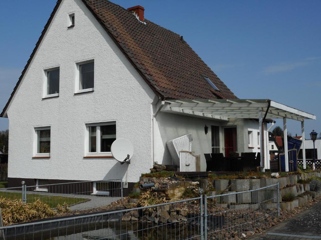 une maison blanche avec un toit marron dans l'établissement Modernes Ferienhaus der besonderen Art mit Garten, à Löhne
